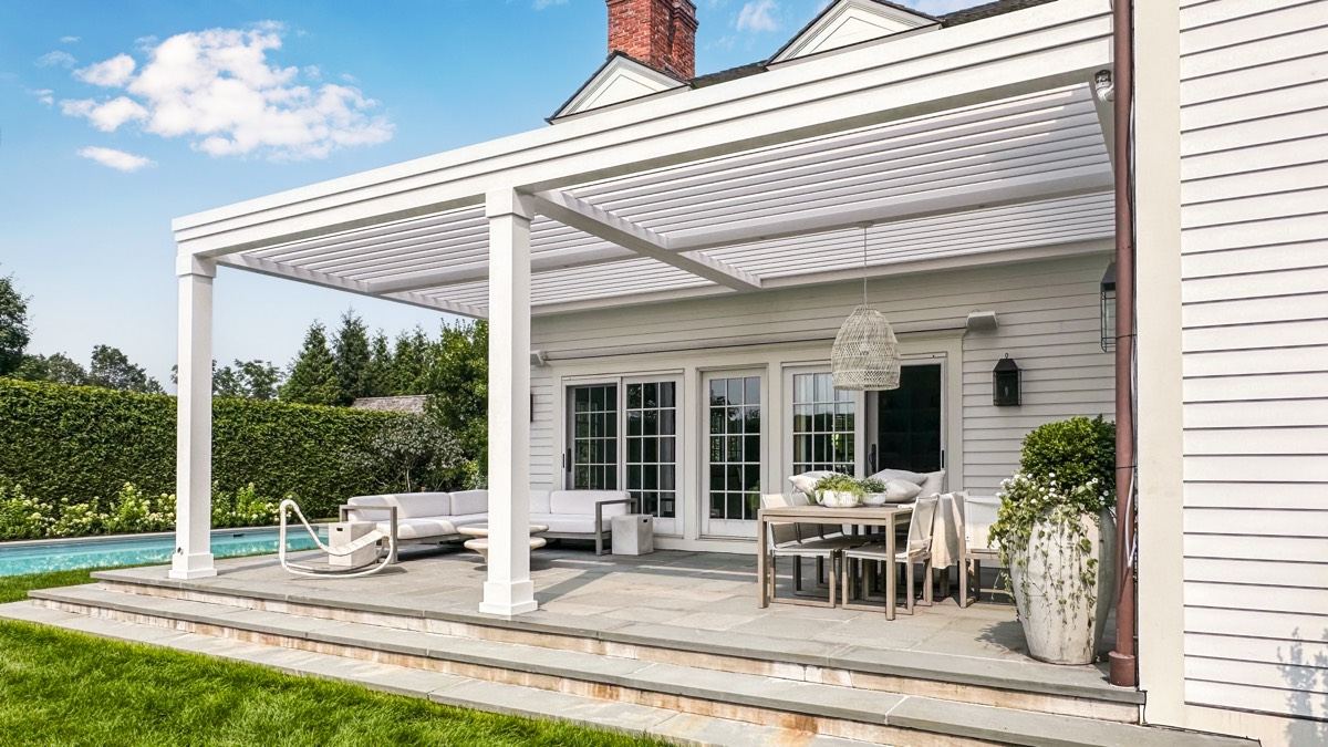 White louvered pergola over dining area on elegant patio