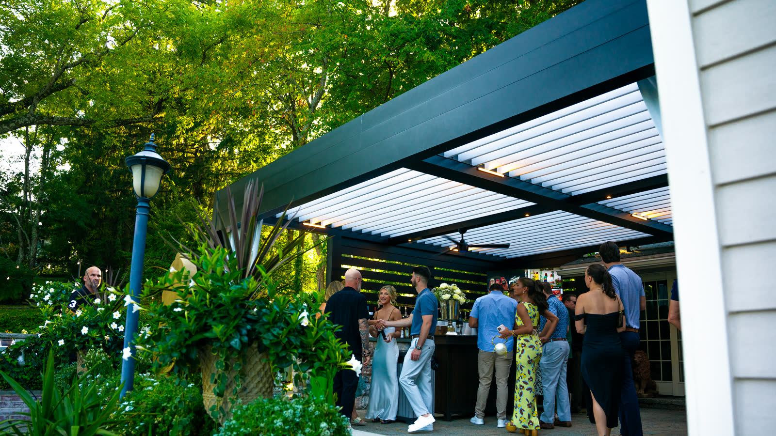 Guests enjoying outdoor space under louvered pergola